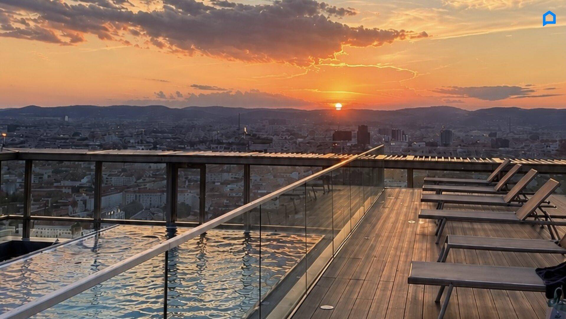 Dachterrasse mit Infinity-Pool und Liegestühlen, ideal für Entspannung bei Sonnenuntergang.