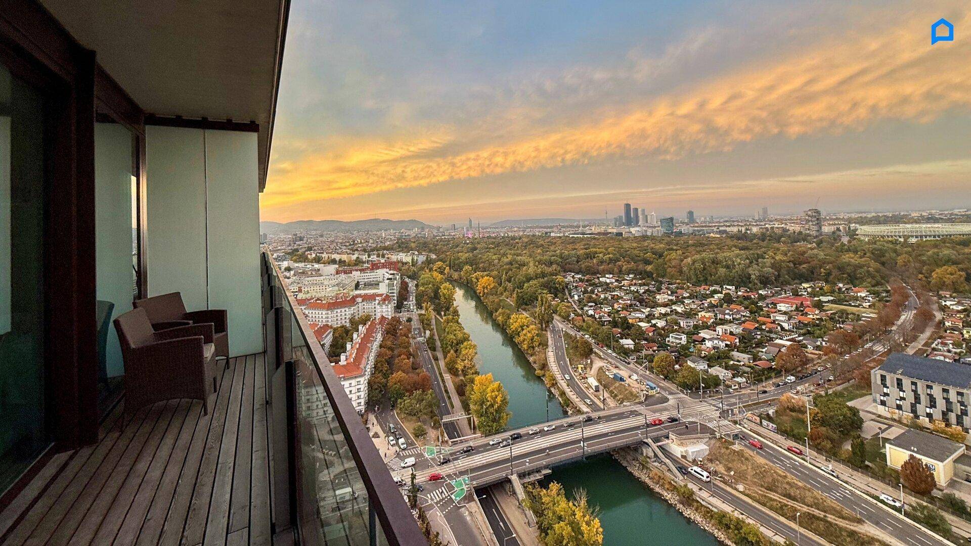 Großer Balkon mit Holzboden und weitem Blick über die Stadt, den Fluss und die umliegende Landschaft.