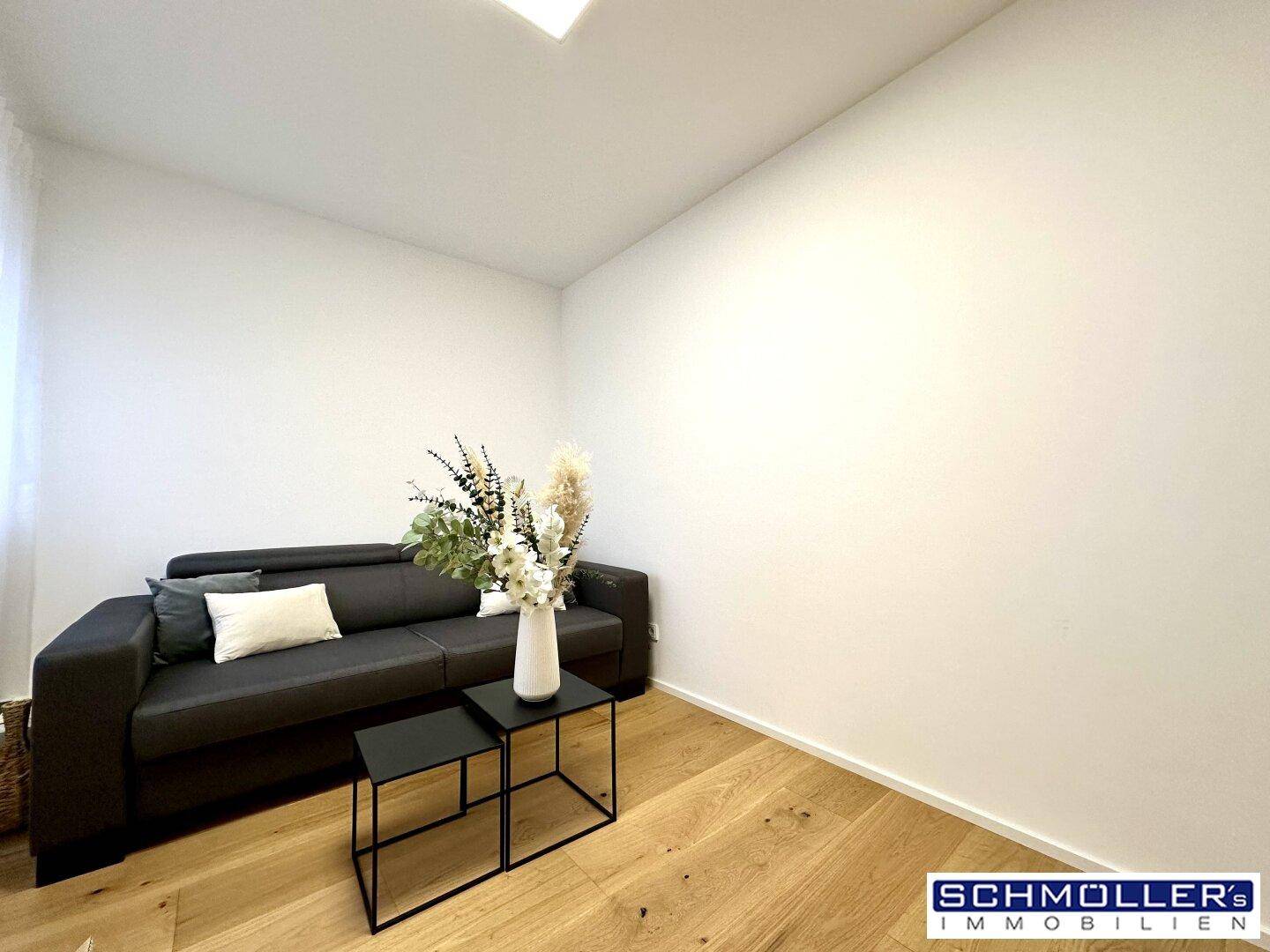 Gemütliches Zimmer mit Holzboden und einem Sofa, ideal als Büro oder Gästezimmer.