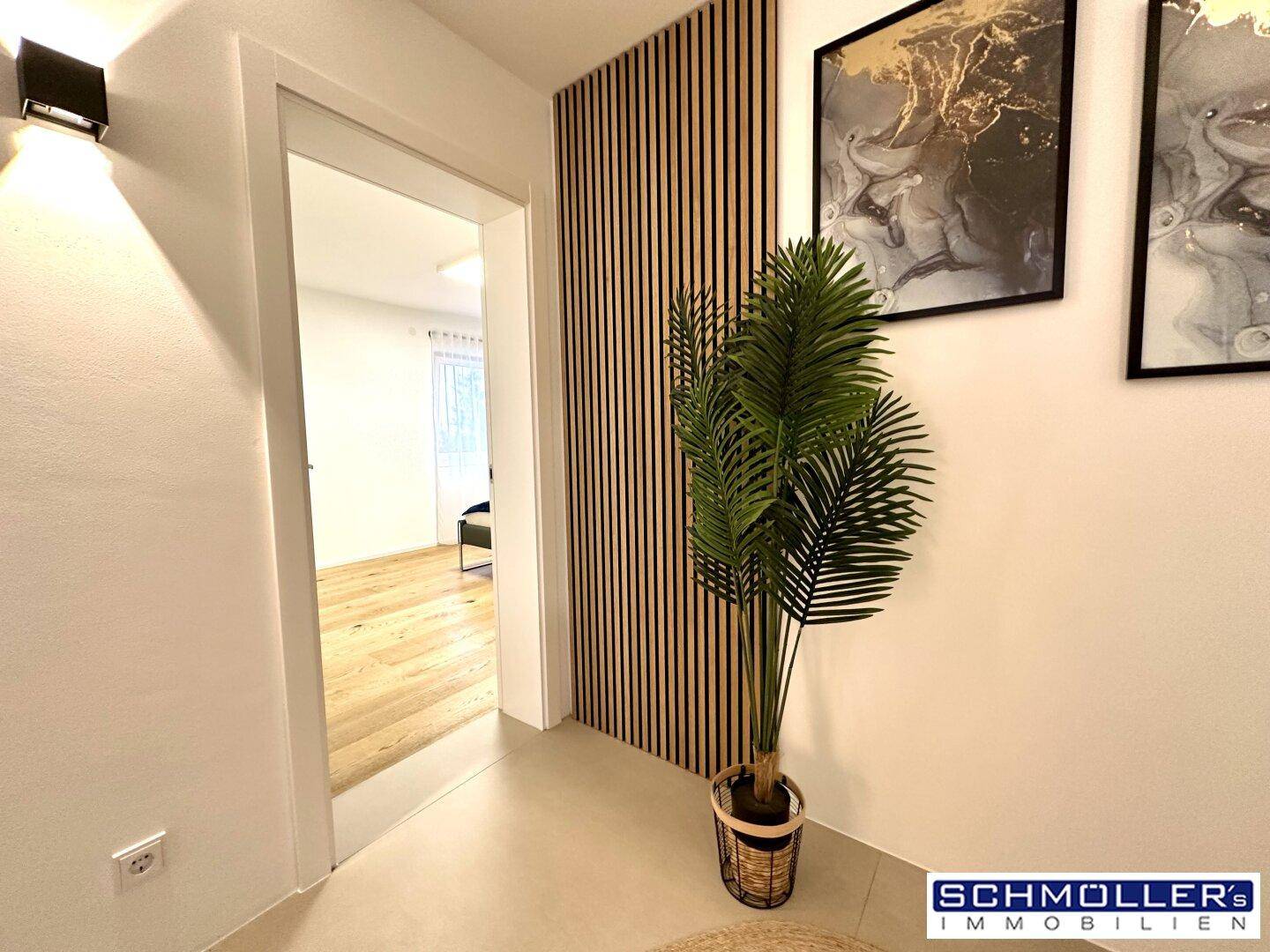 Moderner Flur mit Holzwandverkleidung und Blick in ein weiteres Zimmer.