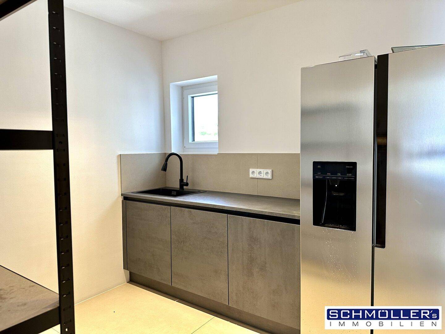 Funktionale Speisekammer mit großem Kühlschrank und kleiner Spüle.