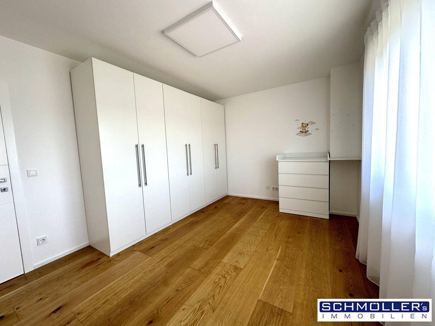 Helles Kinderzimmer mit Einbauschränken und Holzboden, bereit zur Einrichtung.