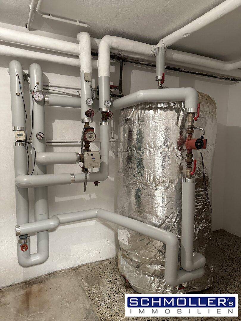 Zentralheizungsanlage mit isoliertem Warmwasserspeicher und umfangreicher Rohrleitungsführung.