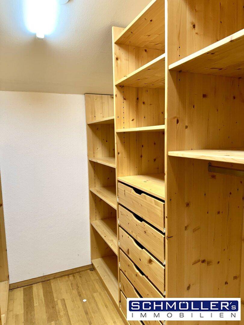 Praktischer Abstellraum mit maßgefertigten Holzregalen und Schubladen für viel Stauraum.