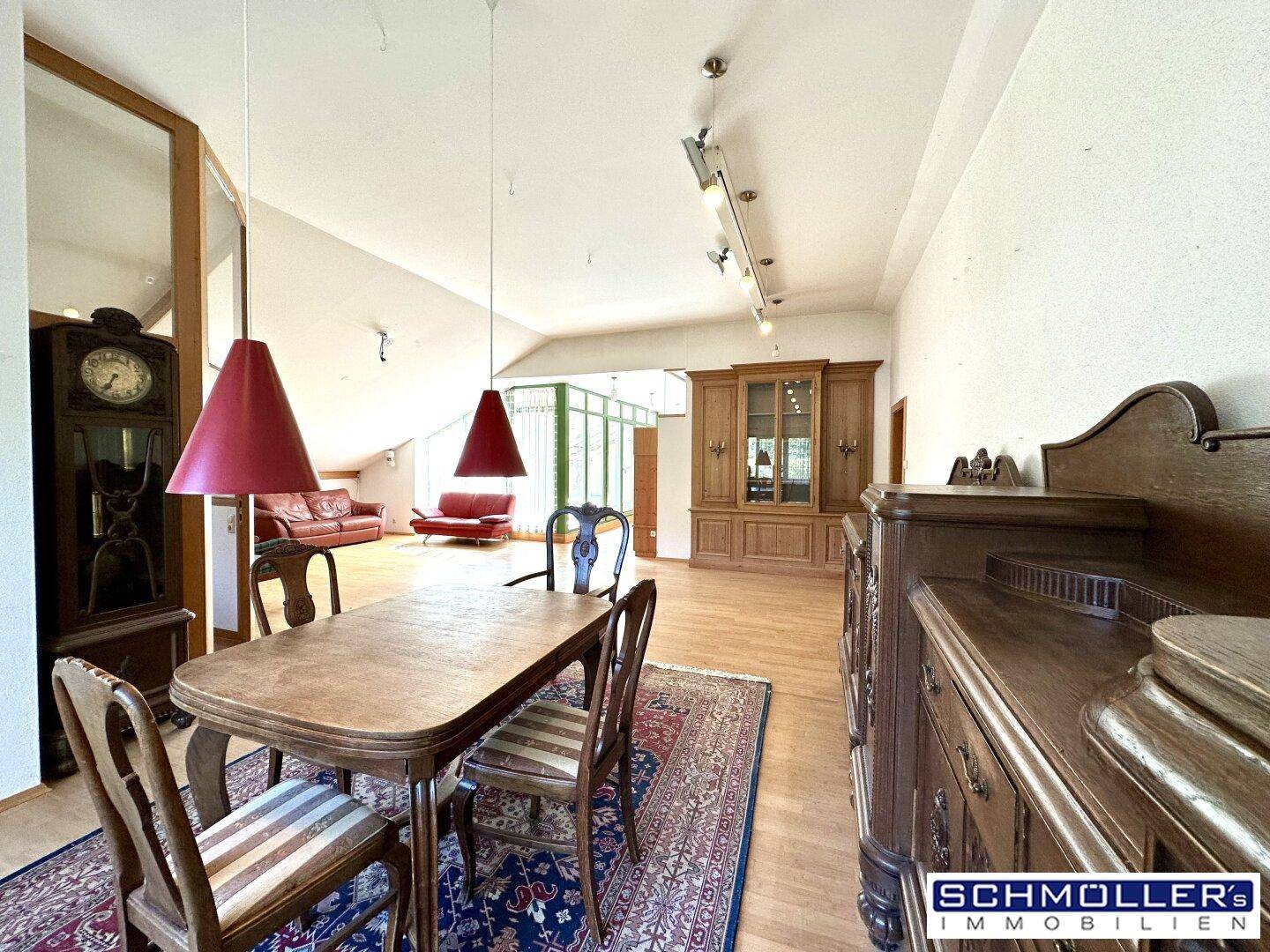 Offener Wohn-Essbereich mit Holzboden, antiken Möbeln und Blick in den Wohnbereich.