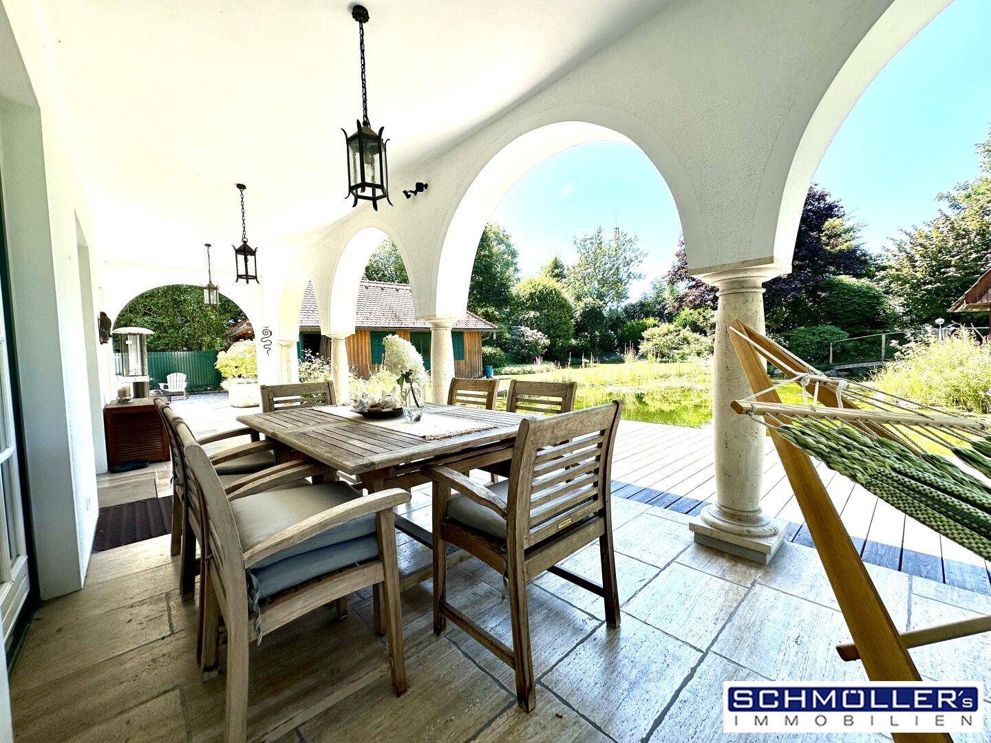 Geräumige Loggia mit Essbereich und entspannendem Blick auf den Teich und Garten.