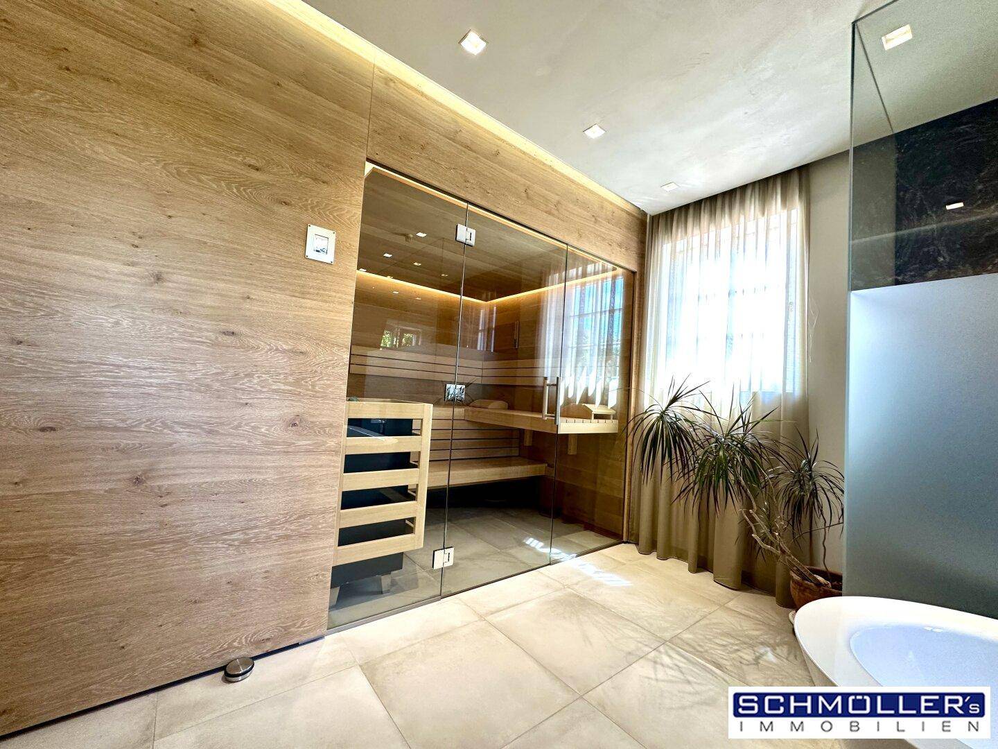 Modernes Badezimmer mit integrierter Sauna, Fliesenboden und Fenster für Tageslicht.