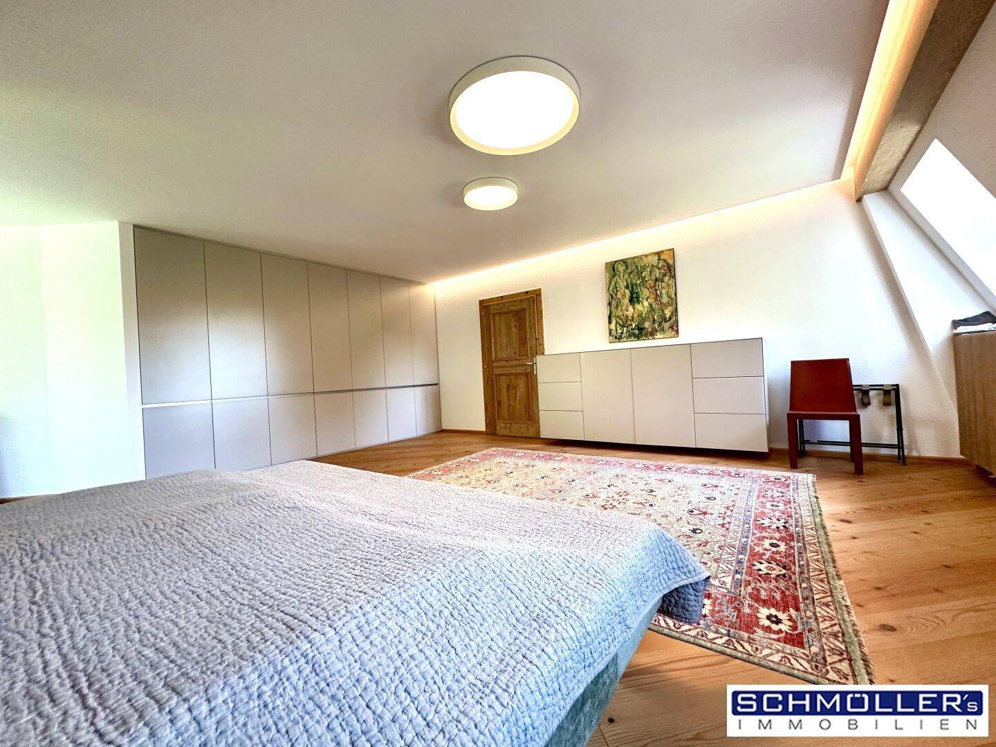 Helles Schlafzimmer mit Holzboden, Einbauschränken und gemütlichem Doppelbett.