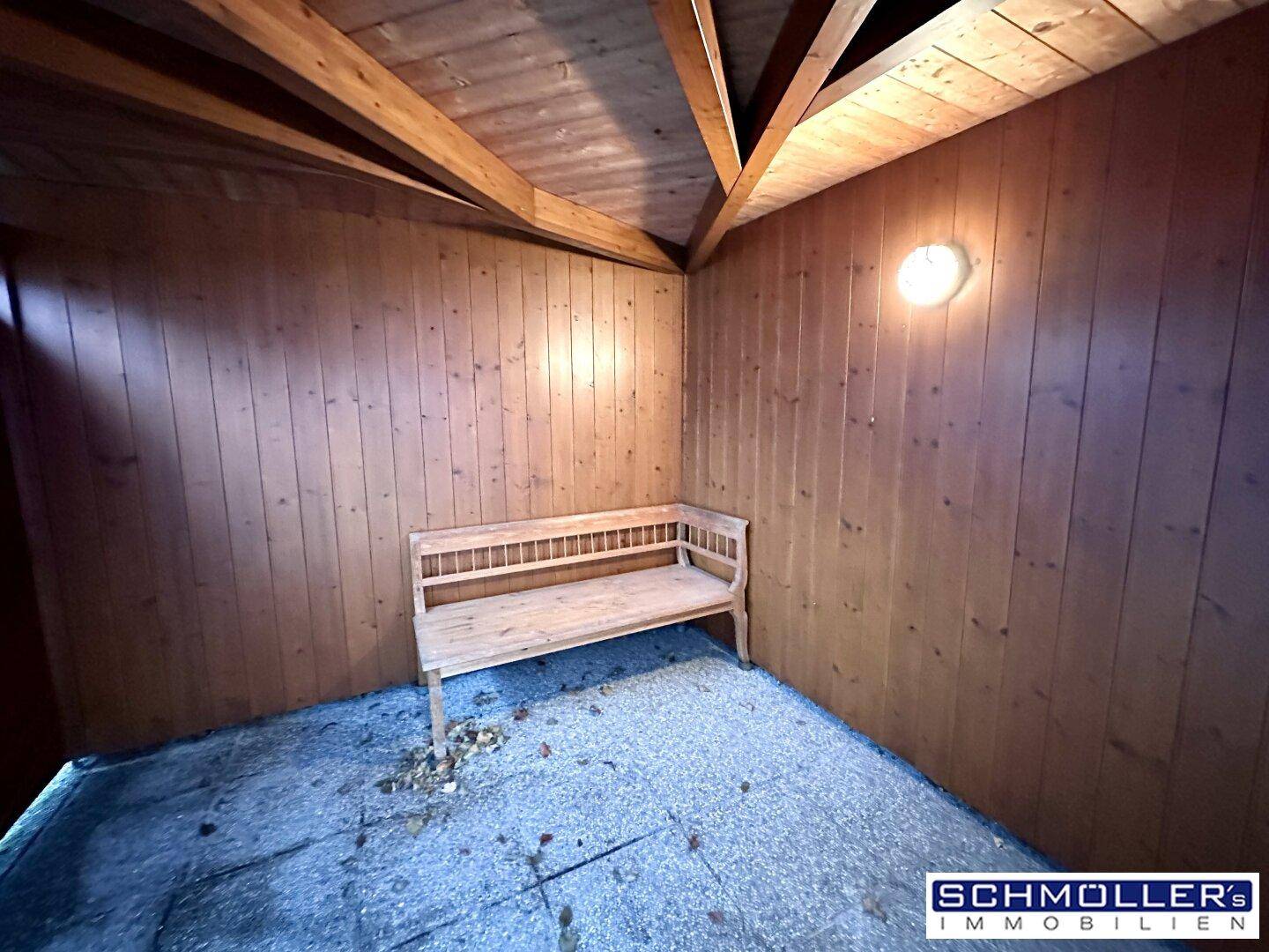Überdachter Sitzbereich aus Holz mit einer Bank, ideal für entspannte Stunden im Freien.