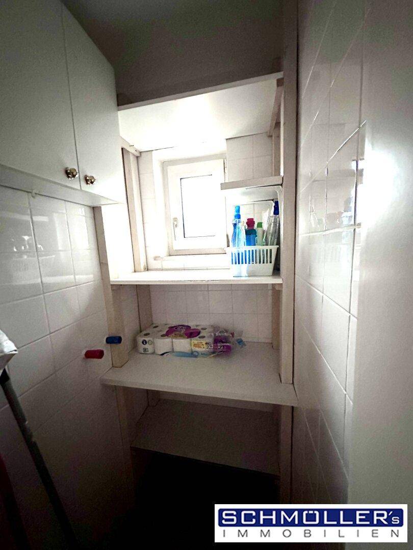 Kleiner Abstellraum mit Fenster, Regalen und Fliesenboden für zusätzlichen Stauraum.