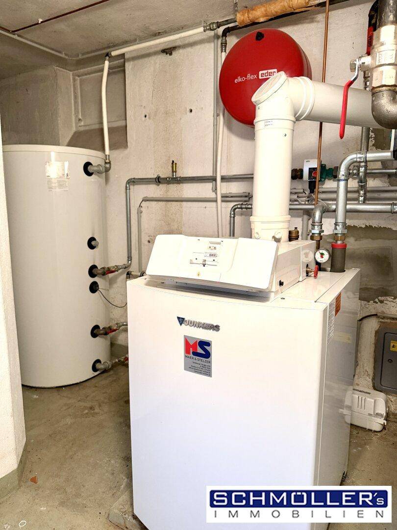 Heizungsraum mit moderner Heizungsanlage und Warmwasserspeicher, gut gewartet.