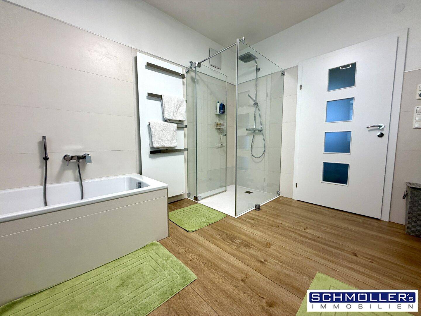 Modernes Badezimmer mit Badewanne, begehbarer Dusche und beheiztem Handtuchhalter.