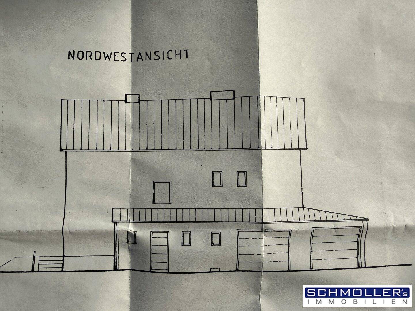 Nordwestansicht des Gebäudes mit Garagen und Eingangsbereich.