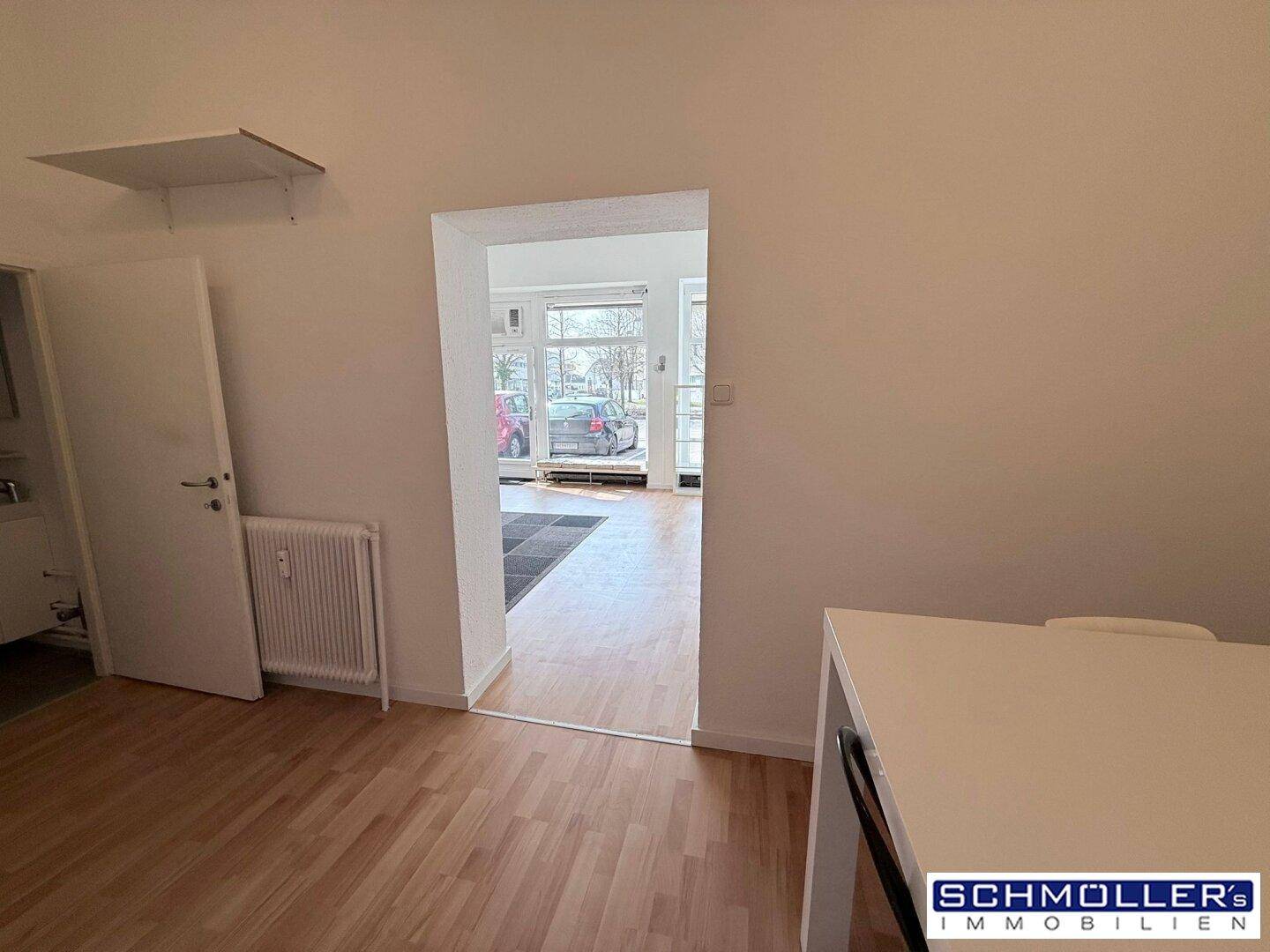Durchgang vom Essbereich zum Hauptbüro, mit Blick auf die großen Fenster und den hellen Arbeitsbereich.