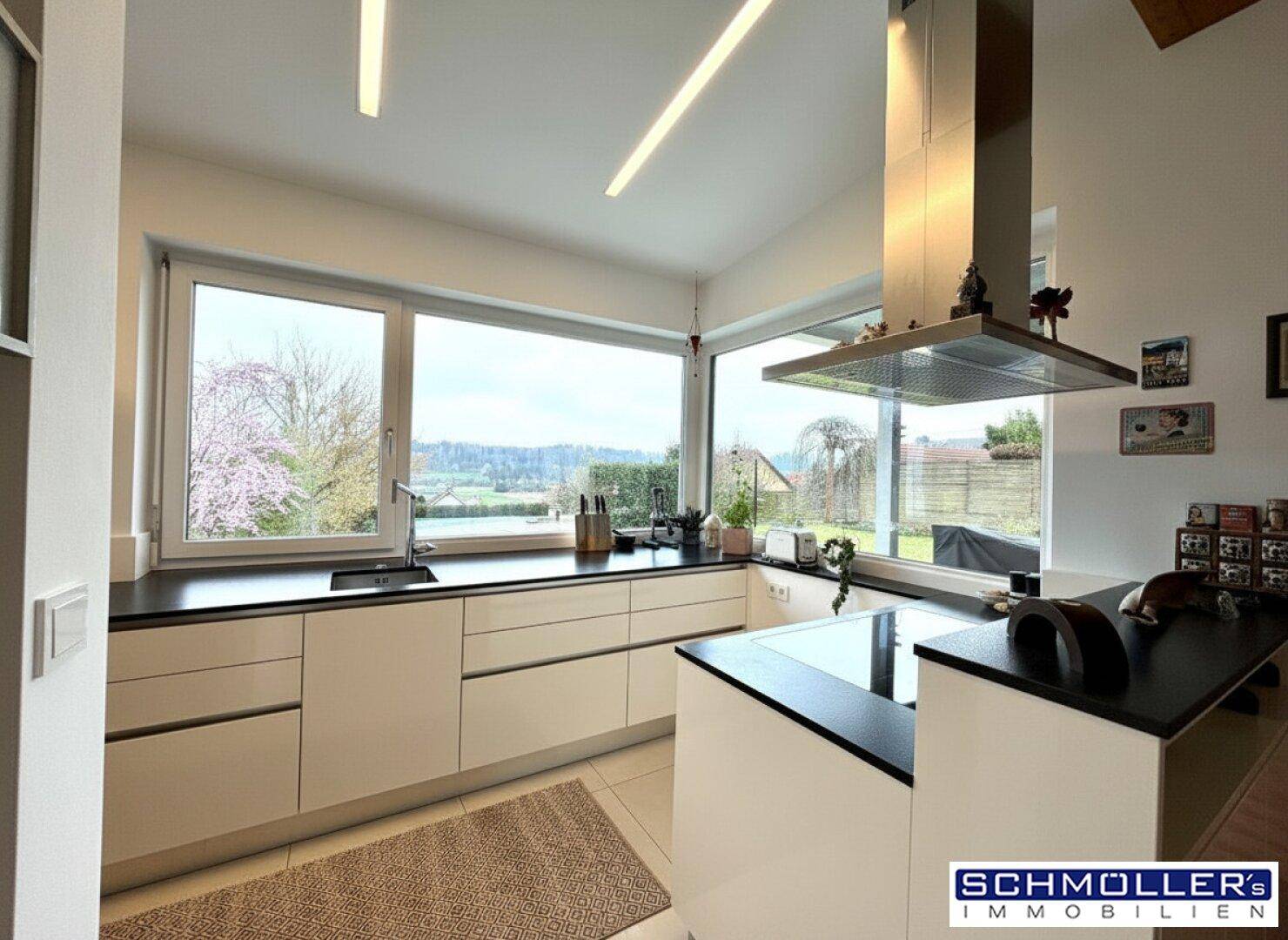 Moderne Küche mit großen Fenstern, die einen weiten Blick in die Landschaft bieten.