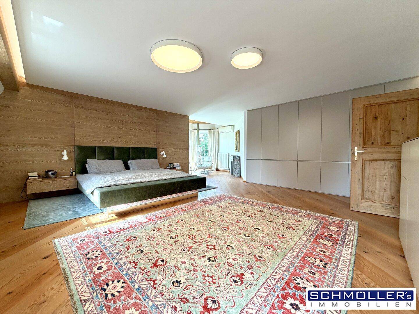 Geräumiges Schlafzimmer mit Holzboden, integrierten Schränken und modernem Doppelbett.
