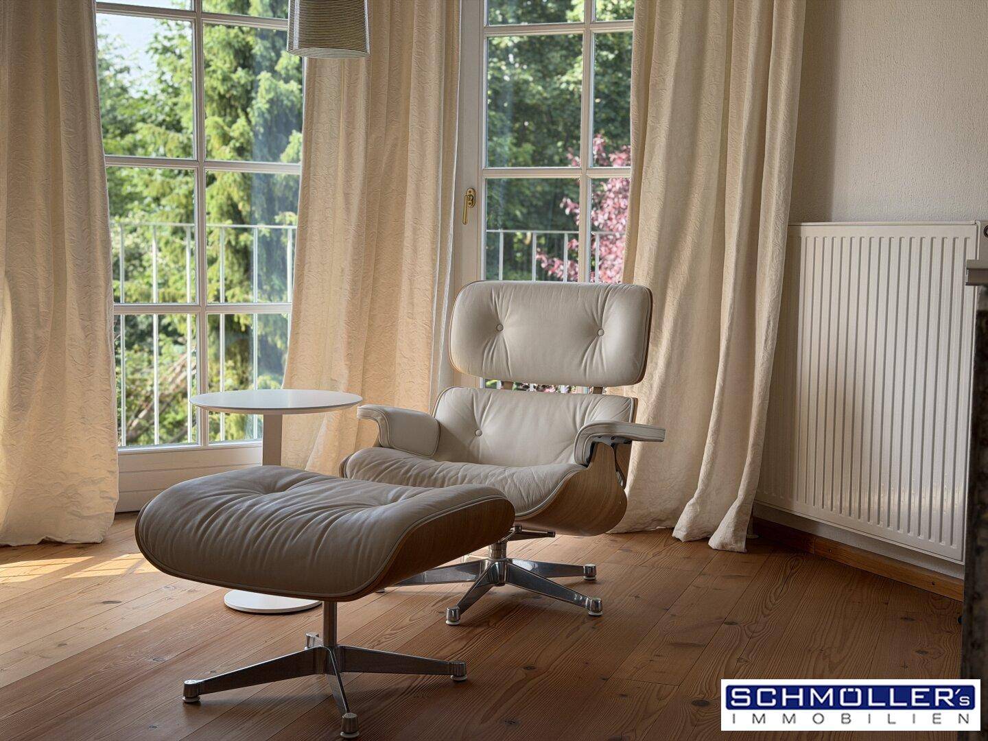 Gemütlicher Lesebereich im Schlafzimmer mit Design-Sessel und Blick ins Grüne.