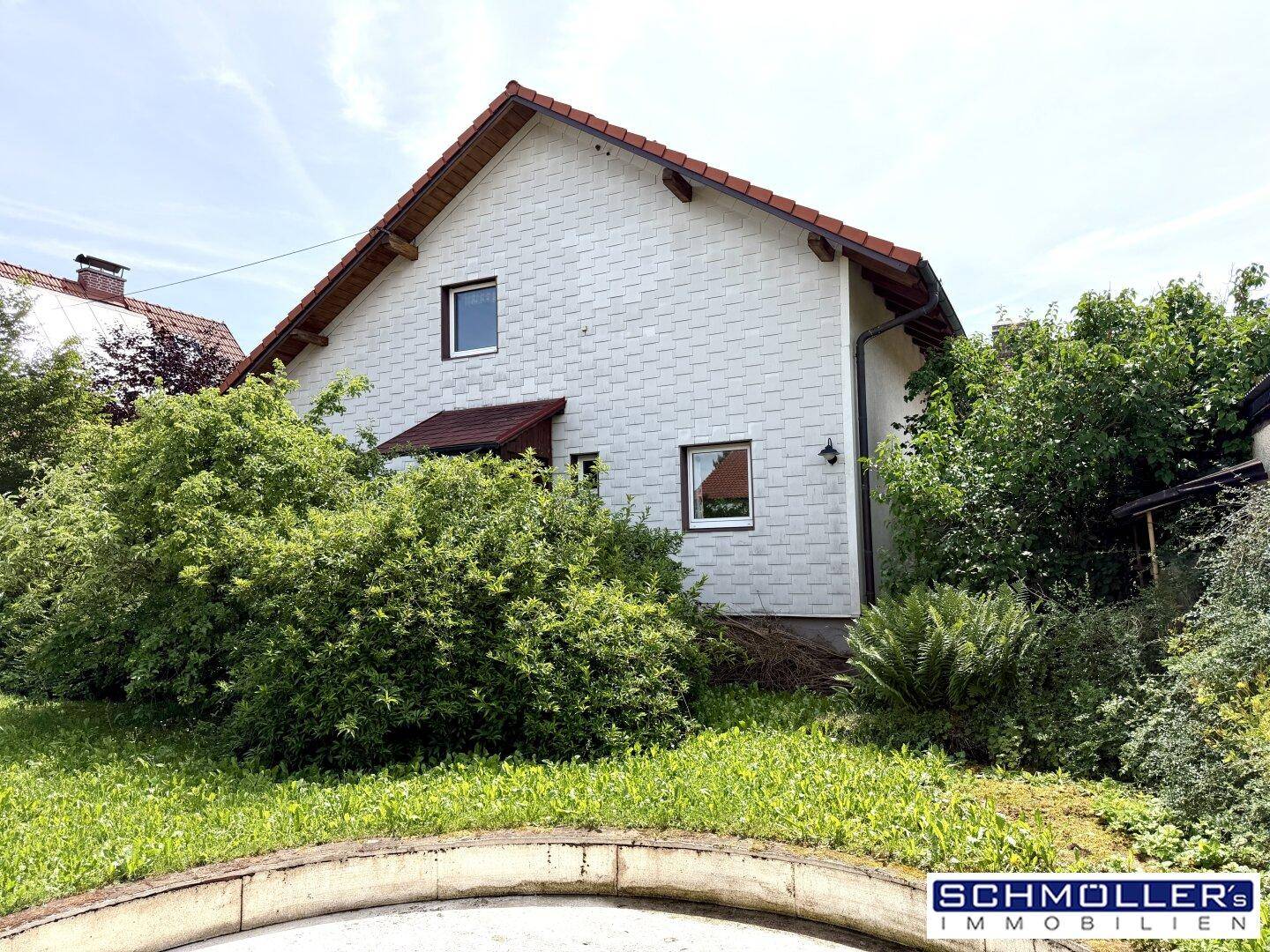 Rückseite des Hauses mit großem, gepflegten Gartenbereich und viel Grünfläche.