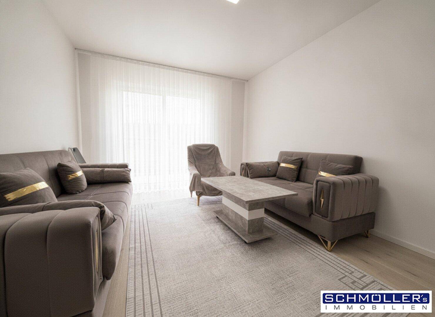Gemütliches Wohnzimmer mit bequemen Sofas, Teppich und hellem Laminatboden.
