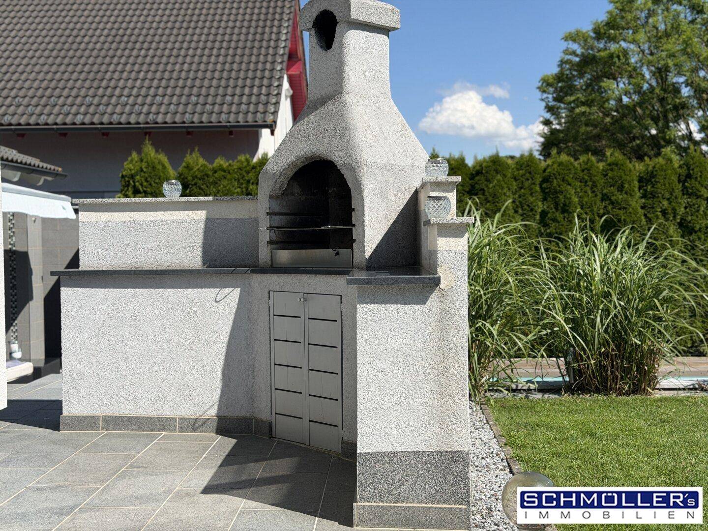 Gemauerter Grillplatz im Garten mit Arbeitsfläche und Stauraum für gesellige Abende.