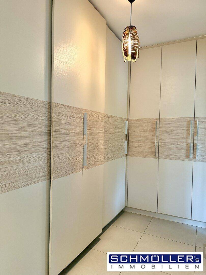 Einbauschränke mit heller Holzmaserung und modernem Deckenlicht in einem Innenraum.