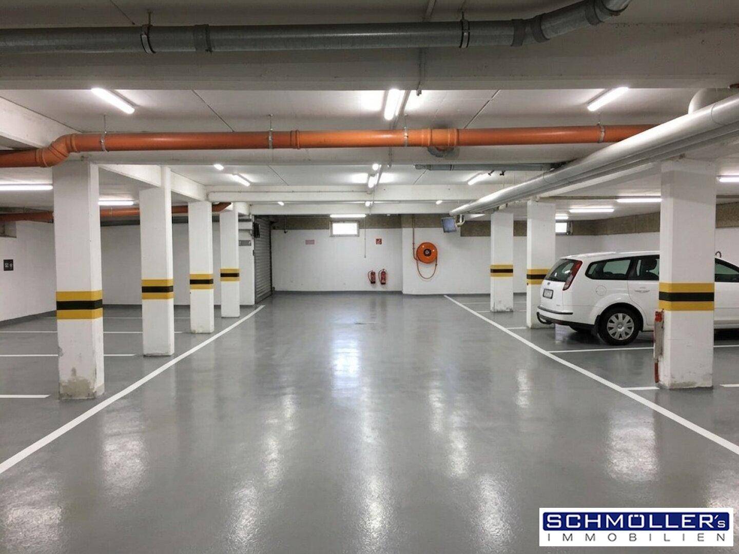 Geräumige Tiefgarage mit markierten Stellplätzen und guter Beleuchtung.