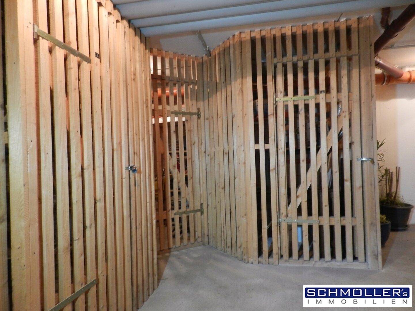 Abstellraum im Keller mit individuellen Holzverschlägen für zusätzlichen Stauraum.