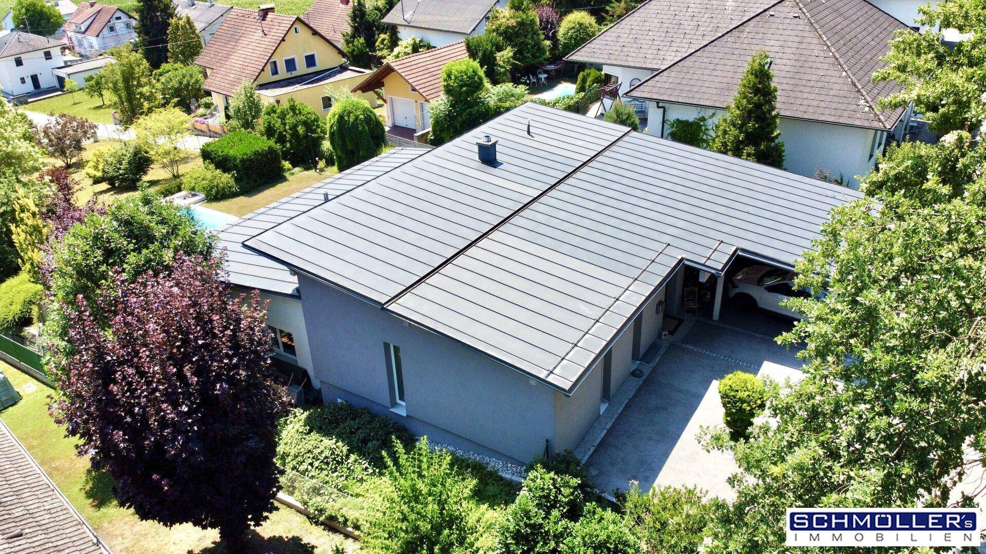 Dachansicht eines modernen Hauses mit Flachdach und integriertem Carport in Wohnsiedlung.