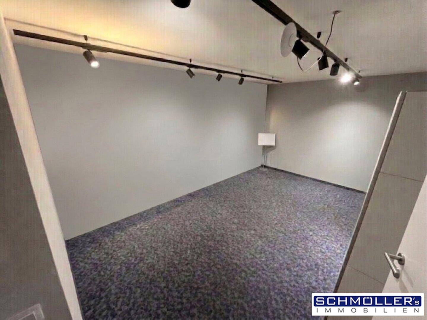 Geräumiges Büro mit Teppichboden und Schienenbeleuchtung, ideal für flexible Arbeitsplatzgestaltung.