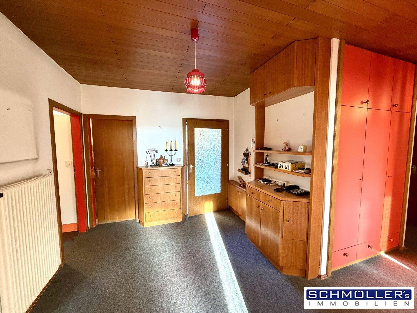 Eingangsbereich mit Holzdecke, Einbauschränken und einem warmen, einladenden Licht.