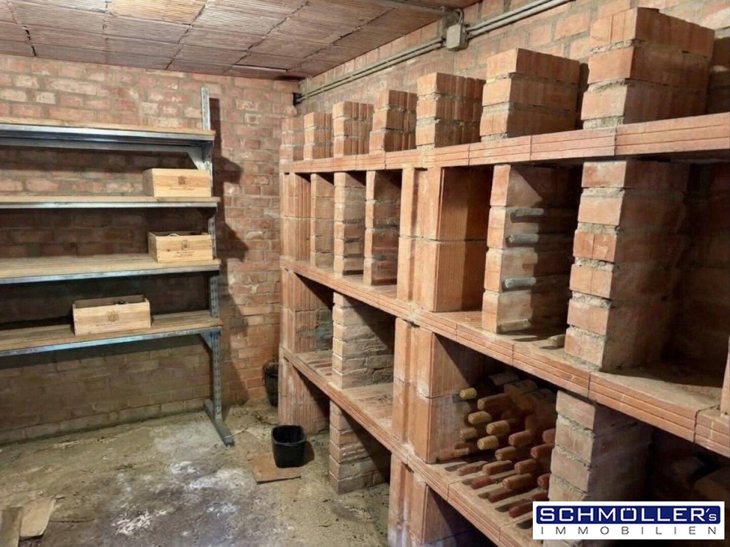 Rustikaler Weinkeller mit Ziegelwänden und gemauerten Regalen für die Weinlagerung.
