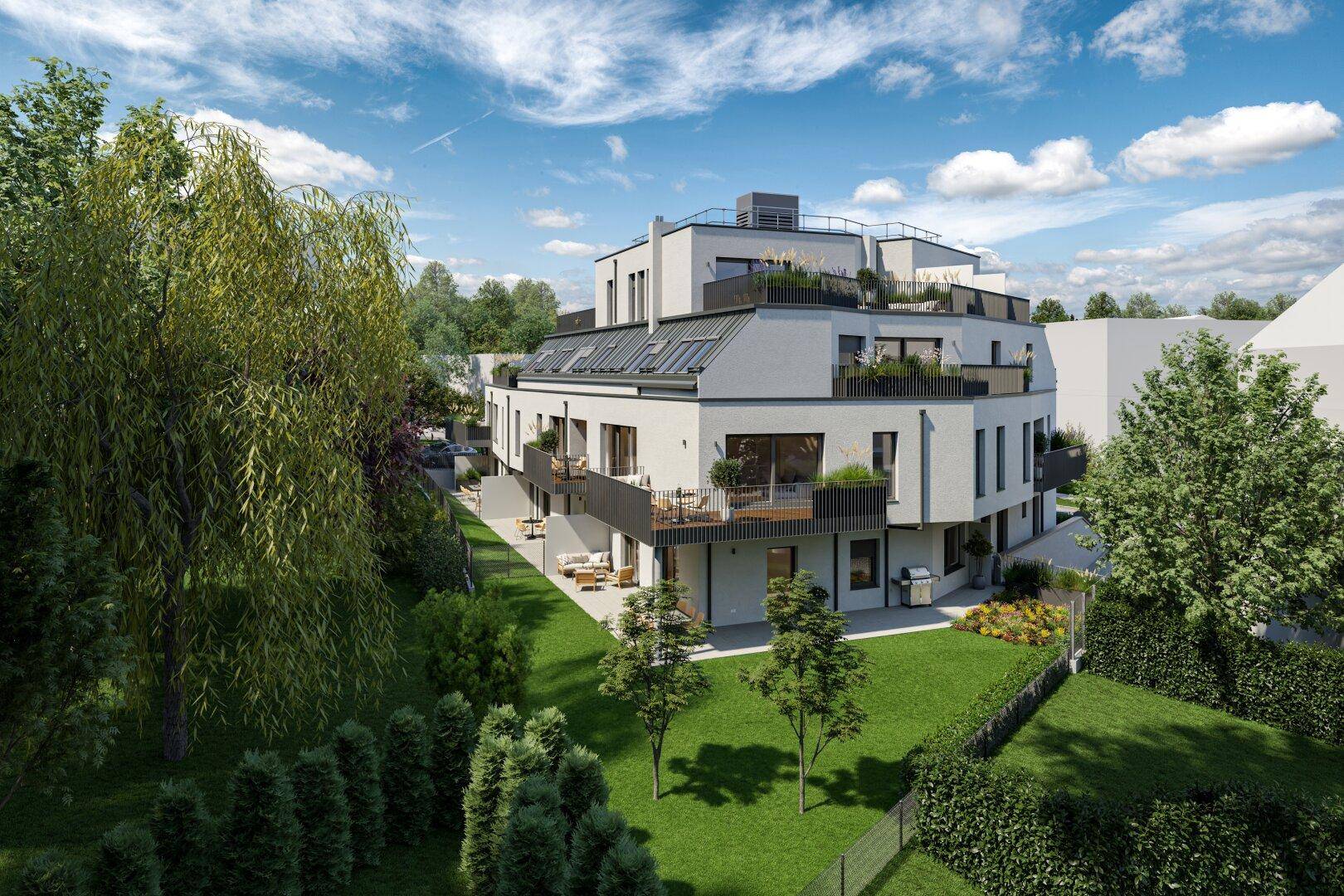 Moderne Wohnanlage mit großzügigen Grünflächen, Terrassen und Balkonen unter blauem Himmel.