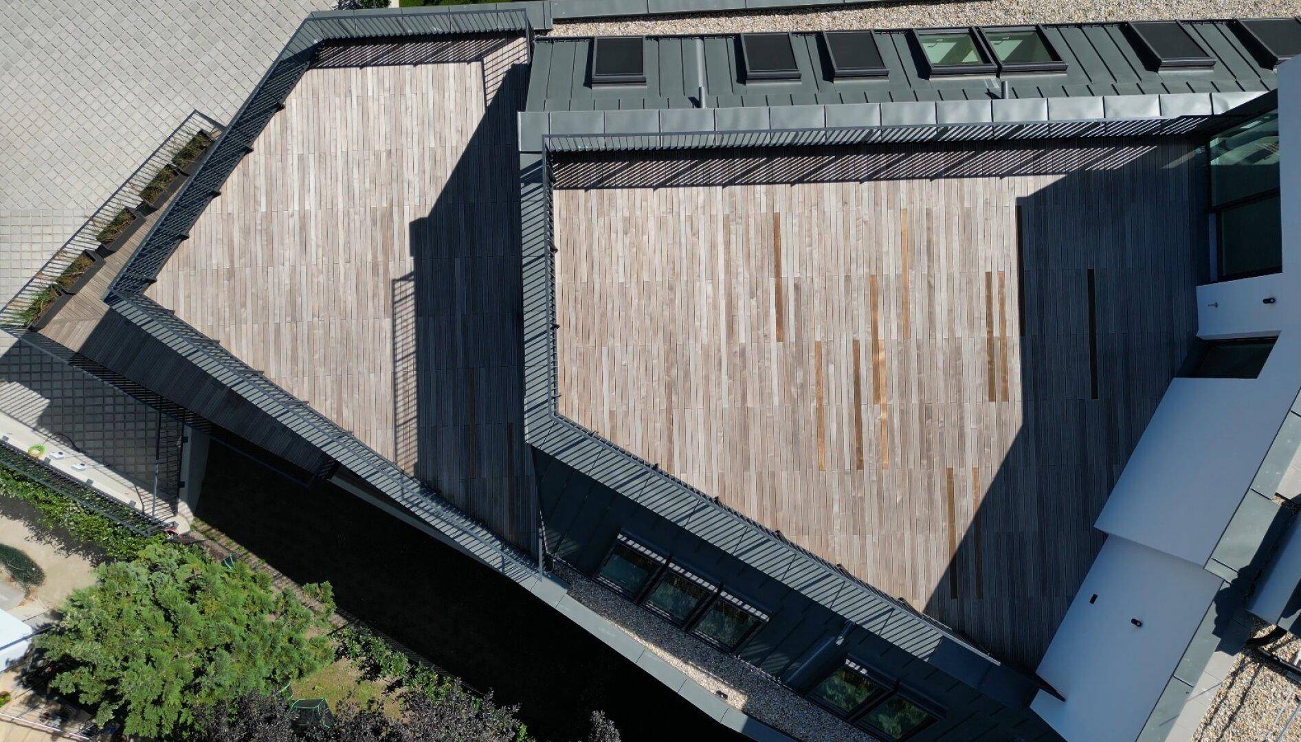 Detailansicht der großzügigen Dachterrassen mit hellem Holzbelag und dunklen Geländern.
