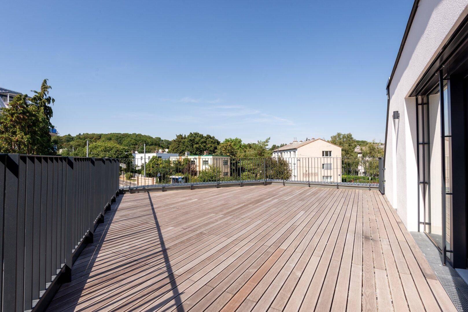Große Holzterrasse mit Metallgeländer und weitem Blick über die Umgebung.