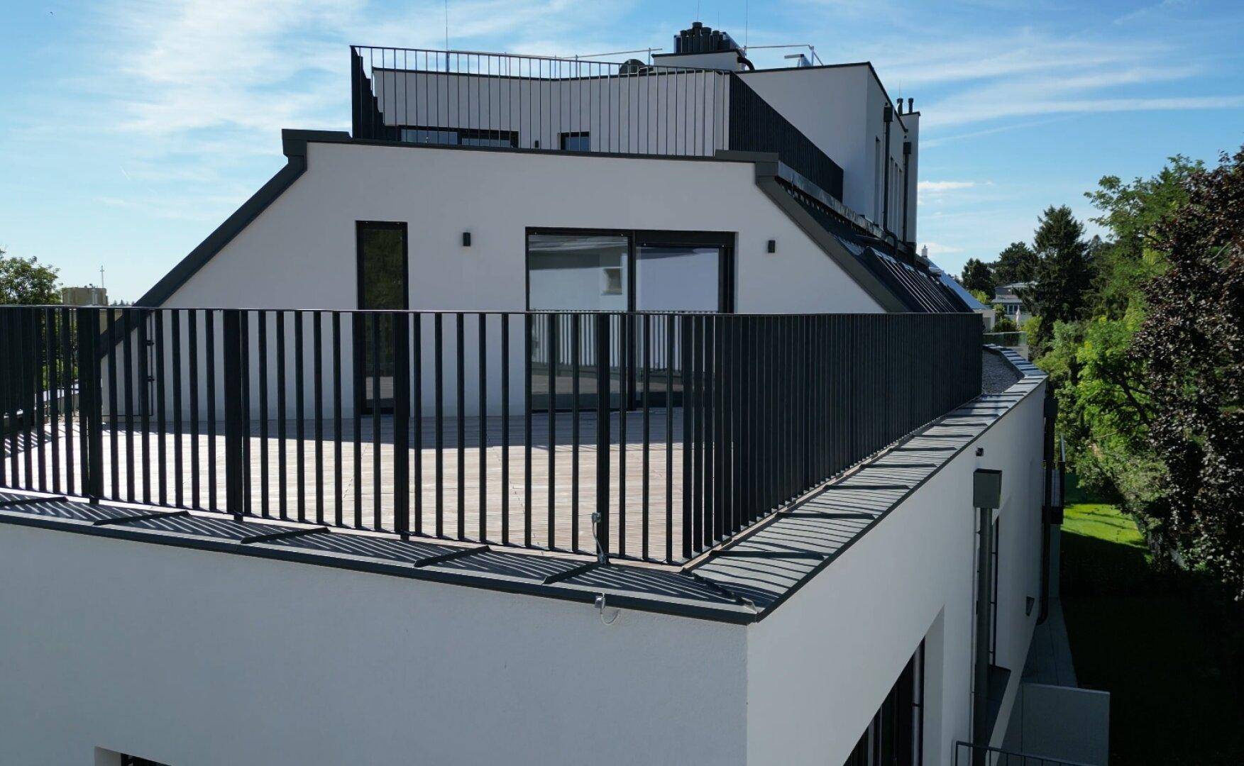 Moderne Architektur des Gebäudes mit mehreren Dachterrassen und klaren Linien.
