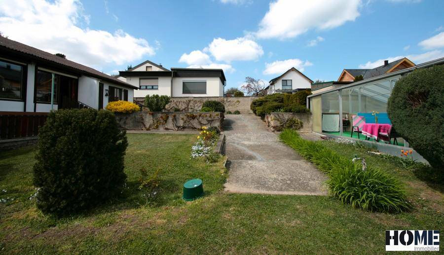 Gartenweg führt durch die Rasenfläche zum Haus und Poolbereich.