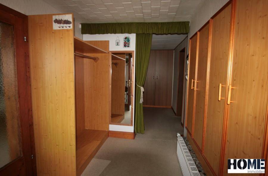 Flur mit praktischen Holzschränken und Garderobe, ideal für Stauraum.