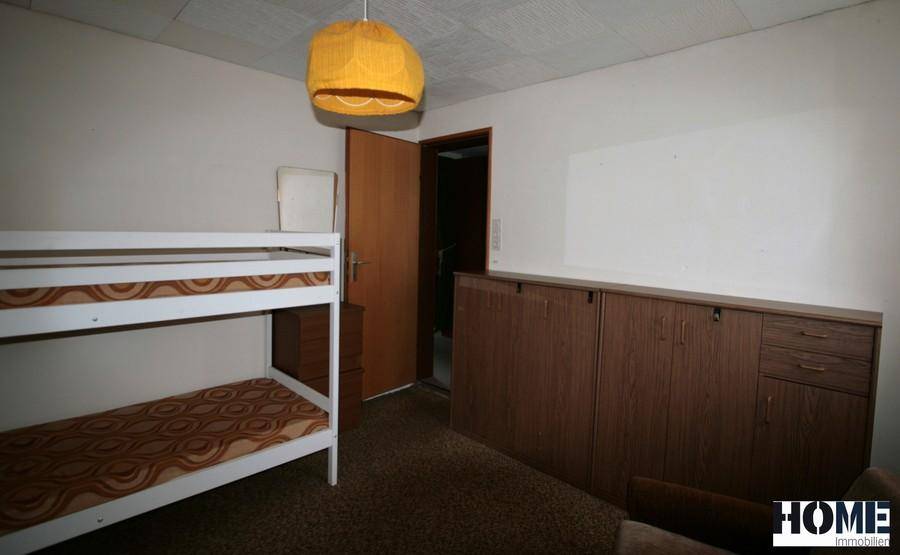 Schlafzimmer mit Etagenbett und integrierten Holzschränken für zusätzlichen Stauraum.