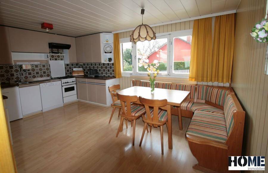 Gemütliche Wohnküche mit traditioneller Eckbank, Holztäfelung und Blick in den Garten.