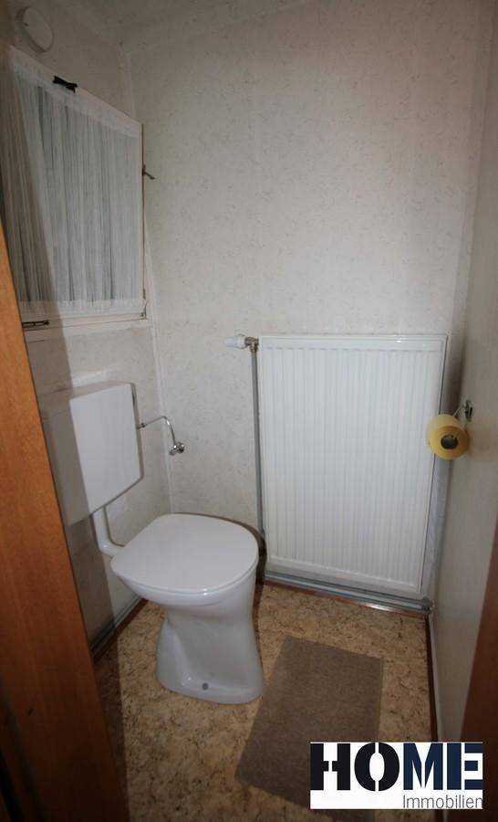 Kleines Gäste-WC mit Fenster, Heizkörper und einfacher Ausstattung.