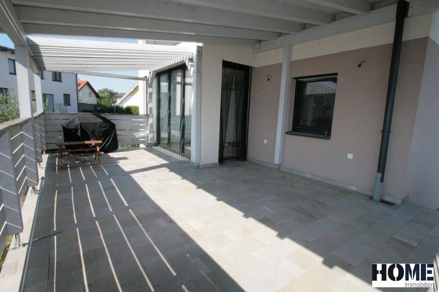 Große überdachte Terrasse mit Fliesenboden und Grillbereich, ideal für entspannte Stunden.