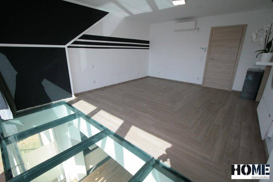 Geräumiger Wohnbereich mit modernem Design, Holzboden, Glasboden und Klimaanlage.