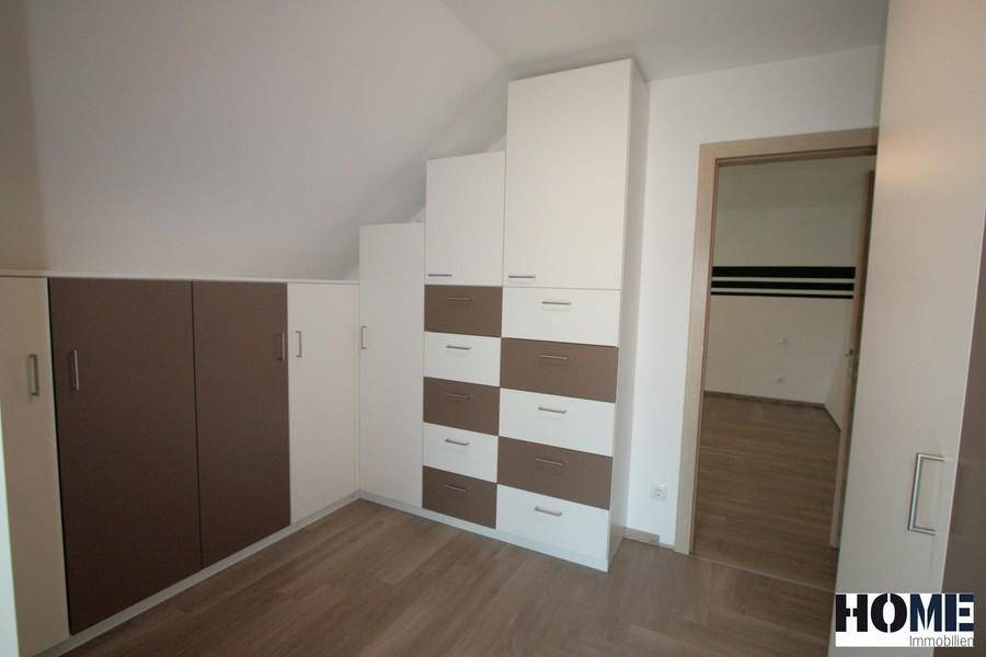 Schlafzimmer mit cleveren Stauraumlösungen und Einbauschränken unter der Dachschräge.