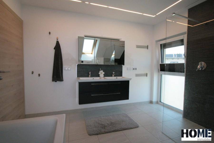 Elegantes Badezimmer mit Doppelwaschbecken, Spiegelschrank und modernen Armaturen.