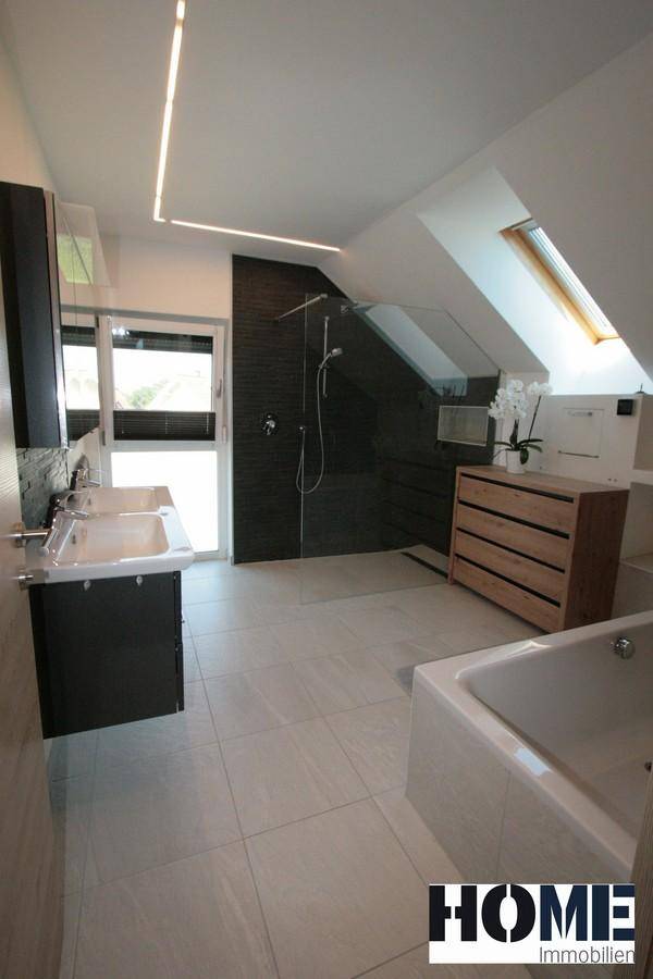Modernes Badezimmer mit begehbarer Dusche, Badewanne, Doppelwaschbecken und Dachfenster.