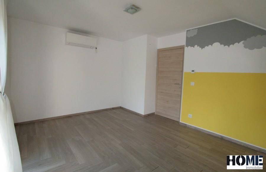 Geräumiges Zimmer mit gelber Wand, Klimaanlage und Holzboden.