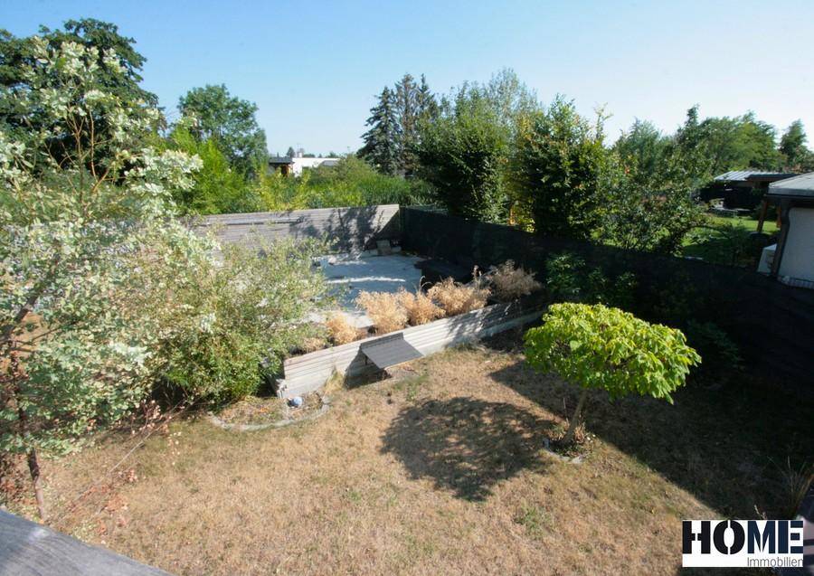 Großer Gartenbereich mit Rasenfläche, Bäumen und einem vorbereiteten Poolbereich.