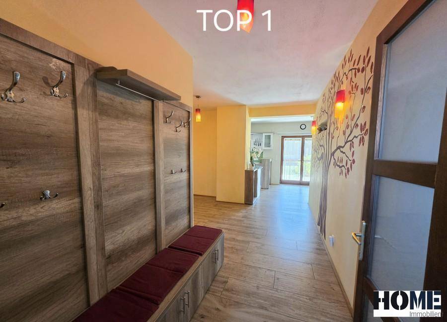 Einladender Flur mit Garderobe, Holzboden und dekorativer Wandgestaltung.