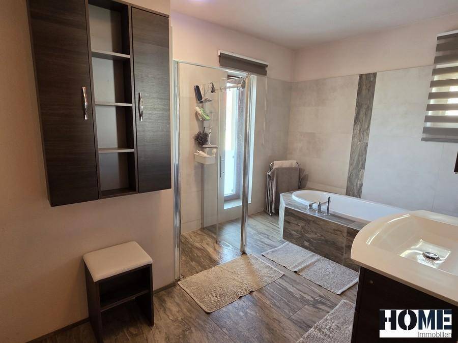 Modernes Badezimmer mit Duschkabine, Badewanne und einem Waschtisch mit Spiegelschrank.