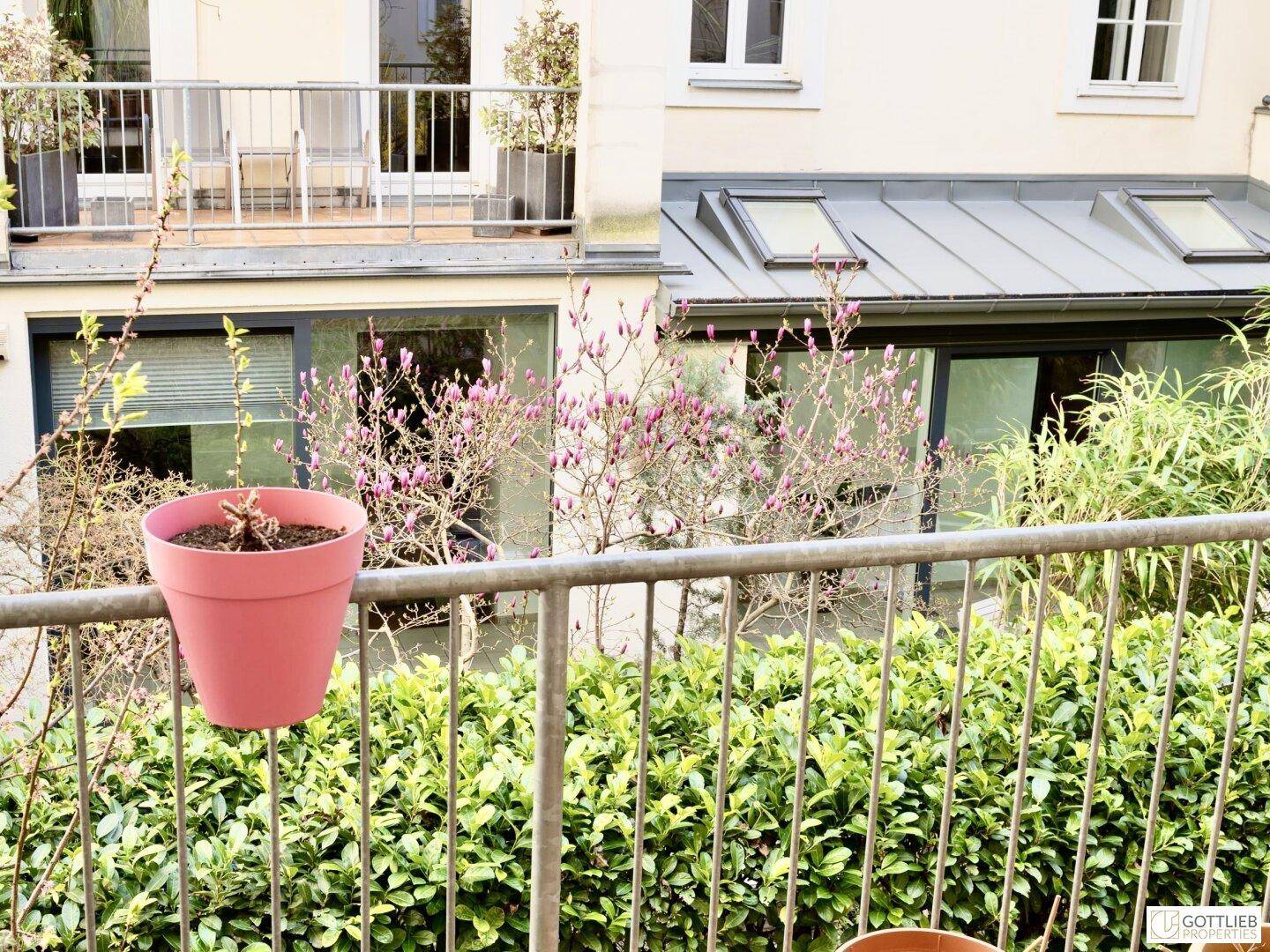 Balkon mit Topfpflanzen und Blick auf weitere Balkone und die Gebäudefassade.